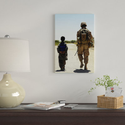 East Urban Home 'Rear View of US Marine Walking Through Nawa Bazaar with an Afghan Boy in Afghanistan' Photographic Print on Canvas
